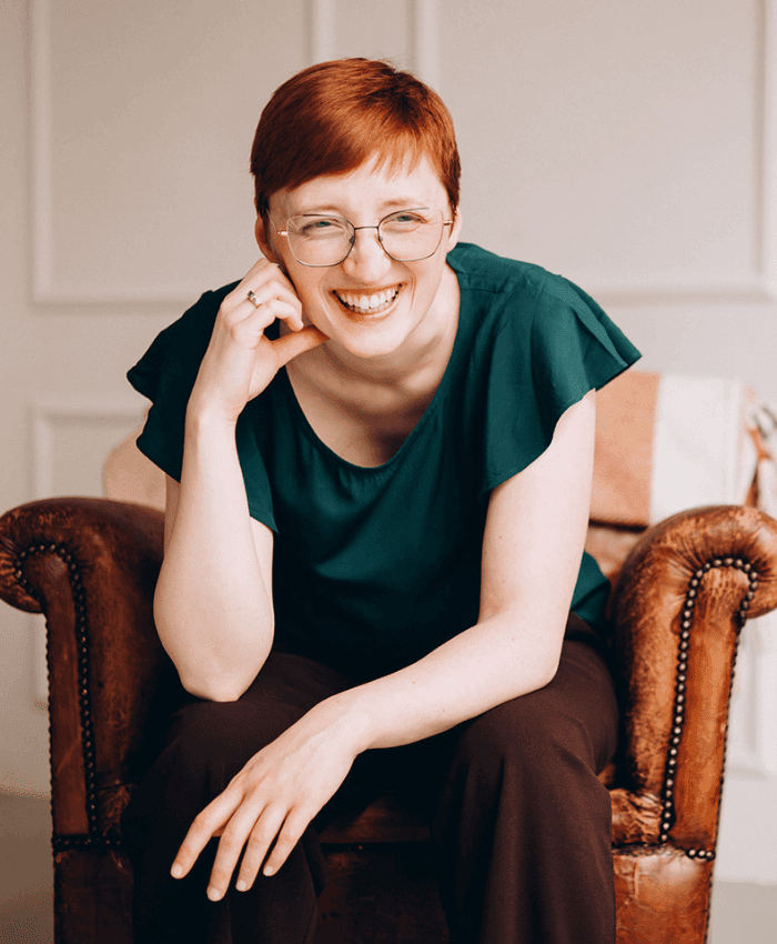 Jane von Klee sitzt lachend auf einem Sessel.